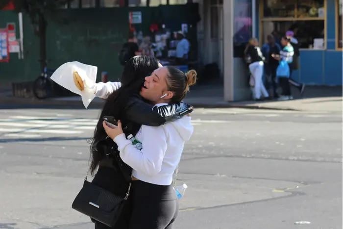 two people hug on a NYC street corner